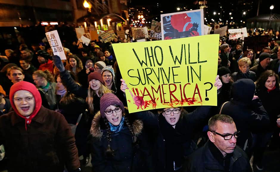 Thousands of protestors march through traffic up Tremont Street, next to the annual Christmas tree lighting ceremony, during a demonstration against the deaths of two unarmed black men at the hands of white police officers in New York City and Ferguson, Mo., in Boston, Thursday, Dec. 4, 2014. AP