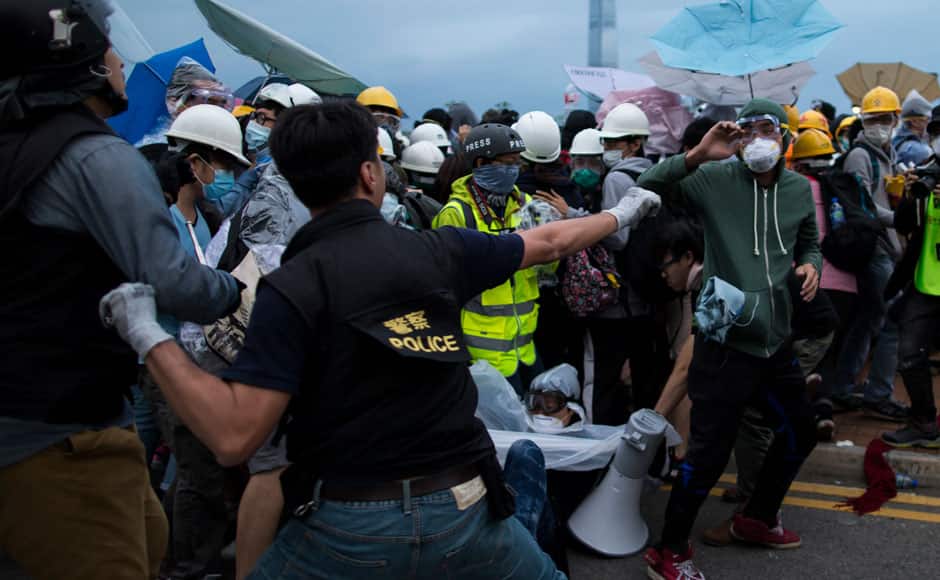 A police officer holds a baton as he shouts at pro-democracy protesters, near the office of the Chief Executive in Hong Kong December 1, 2014. Hong Kong police baton-charged and pepper-sprayed thousands of pro-democracy demonstrators in the early hours of Monday who were trying to encircle government headquarters, defying orders to retreat after more than two months of protests. REUTERS