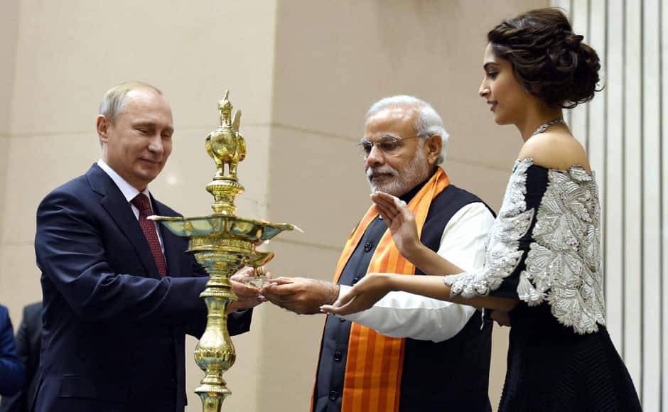 New Delhi: Prime Minister Narendra Modi with Russian President Vladimir lighting the lamp as actress Sonam Kapoor looks on during the World Diamond Conference in New Delhi on Thursday. PTI