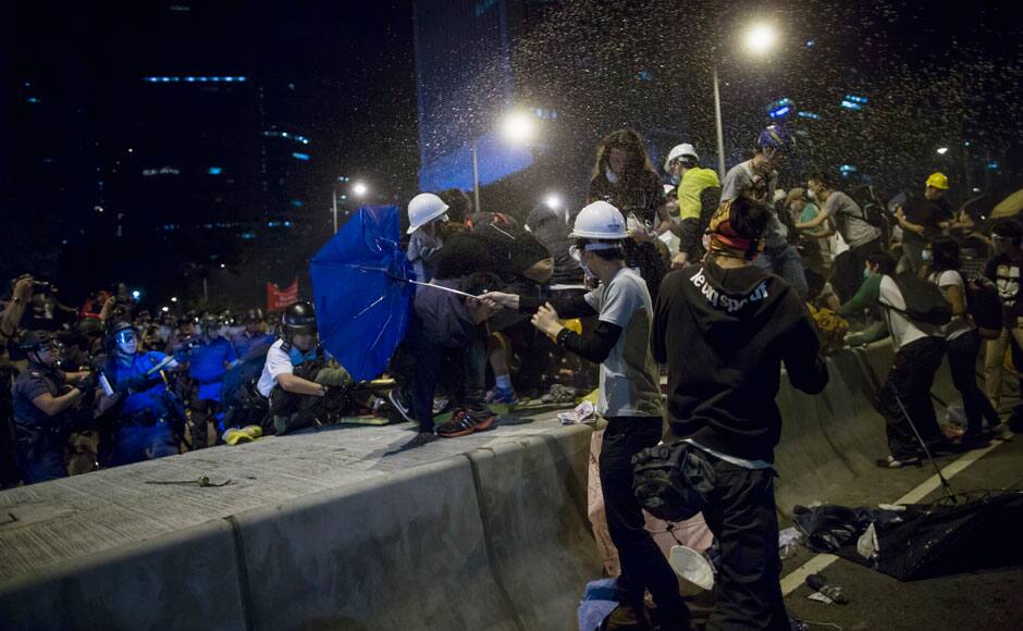 Riot police use pepper spray as they attempt to clear a demonstration site close to the chief executive office in Hong Kong December 1, 2014. Hundreds of Hong Kong pro-democracy activists scuffled with police on Sunday as they tried to encircle government headquarters, defying orders for protesters to retreat after more than two months of demonstrations. REUTERS