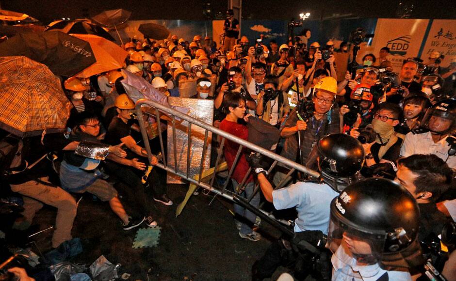 Hong Kong : Pro-democracy protesters scuffle with police officers on the main road outside the government headquarters in Hong Kong Sunday, Nov.30, 2014. Hundreds of pro-democracy protesters faced off with Hong Kong police late Sunday, stepping up their movement for genuine democratic reforms after being camped out on the city's streets for more than two months.AP/ PTI