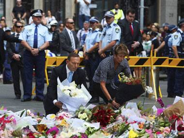 Australin PM Tony Abbott along with wife Margie lay flowers at the Sydney siege site. AP