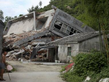 In this photo taken July 16, 2014, a man stands near the razed remains of a Catholic church in a village in Pingyang county of Wenzhou in eastern China’s Zhejiang province. AP 