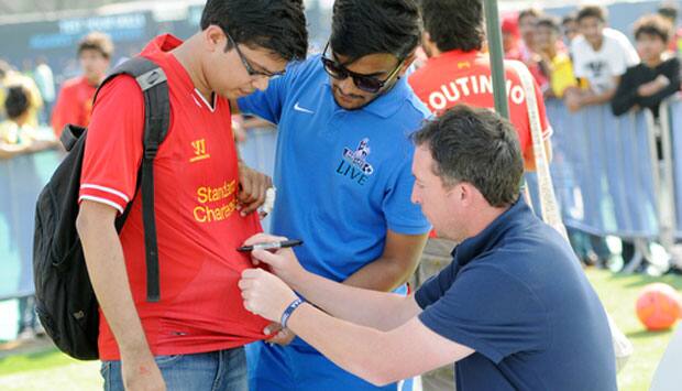 Robbie Fowler signs an autograph.