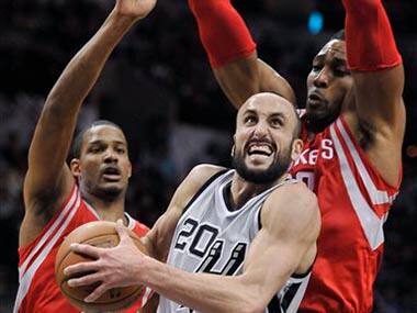 San Antonio Spurs guard Manu Ginobili, drives between Houston Rockets center Dwight Howard, right, and forward Trevor Ariza. San Antonio won 110-106. AP