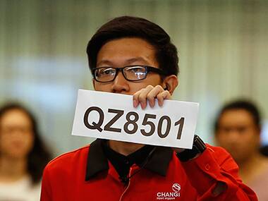 A staff member holding the a sign with the missing flight number. Reuters 