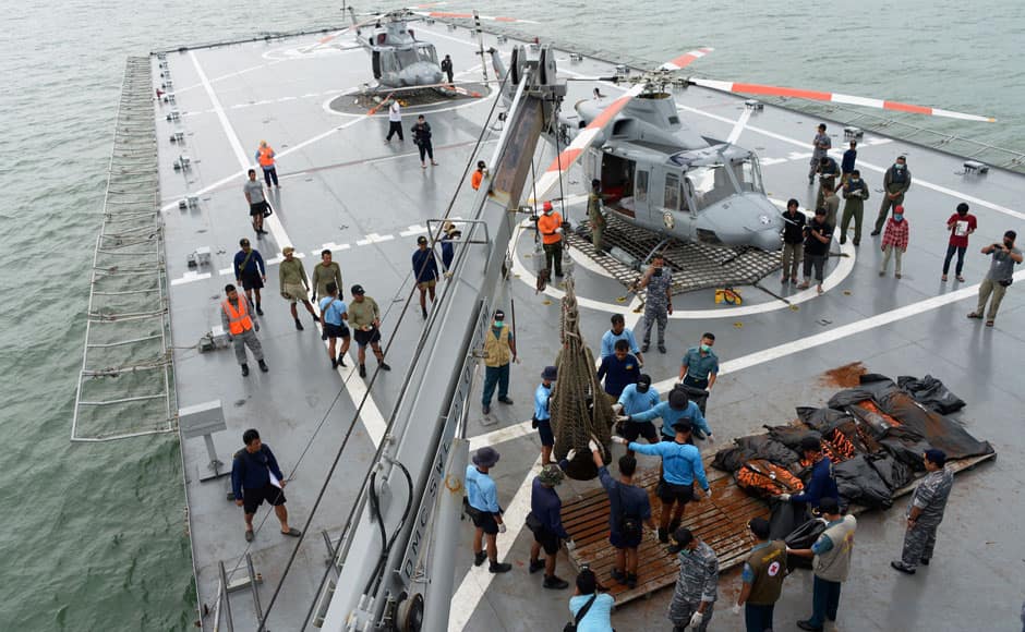 Indonesian Navy personnel evacuate recovered dead bodies of passengers from AirAsia flight QZ8501, on the the deck of the Indonesian Navy vessel KRI Banda Aceh, at sea January 3, 2015. Ships searching for the wreck of an AirAsia passenger jet that crashed with 162 people on board have pinpointed two 