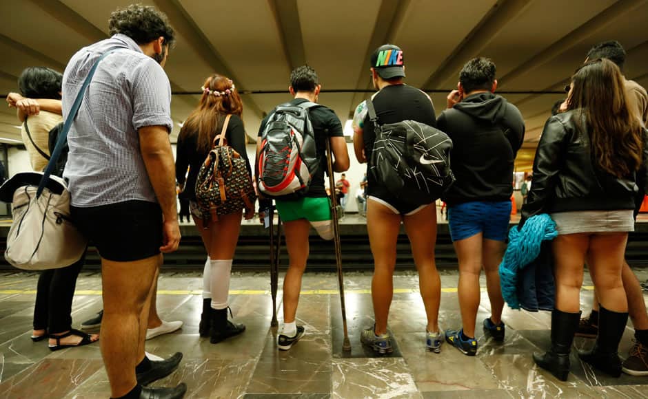 Passengers without pants wait for the subway train during 