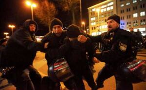 Two riot policemen (R and 2nd L) struggle with a protestor when some fighting erupted during an anti-racism demonstration against the anti-immigration movement Patriotic Europeans Against the Islamisation of the West (PEGIDA) in the centre of Munich, January 12, 2015. REUTERS