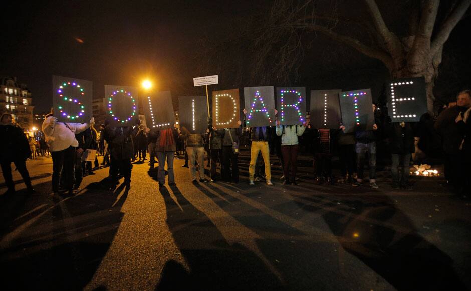 People hold up a sign reading 