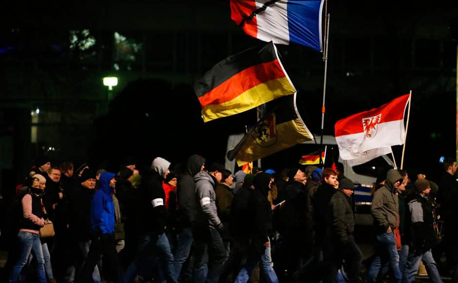 Supporters of anti-immigration movement Patriotic Europeans Against the Islamisation of the West (PEGIDA) carry French, Polish and German flags during a demonstration in Dresden January 12, 2015. REUTERS