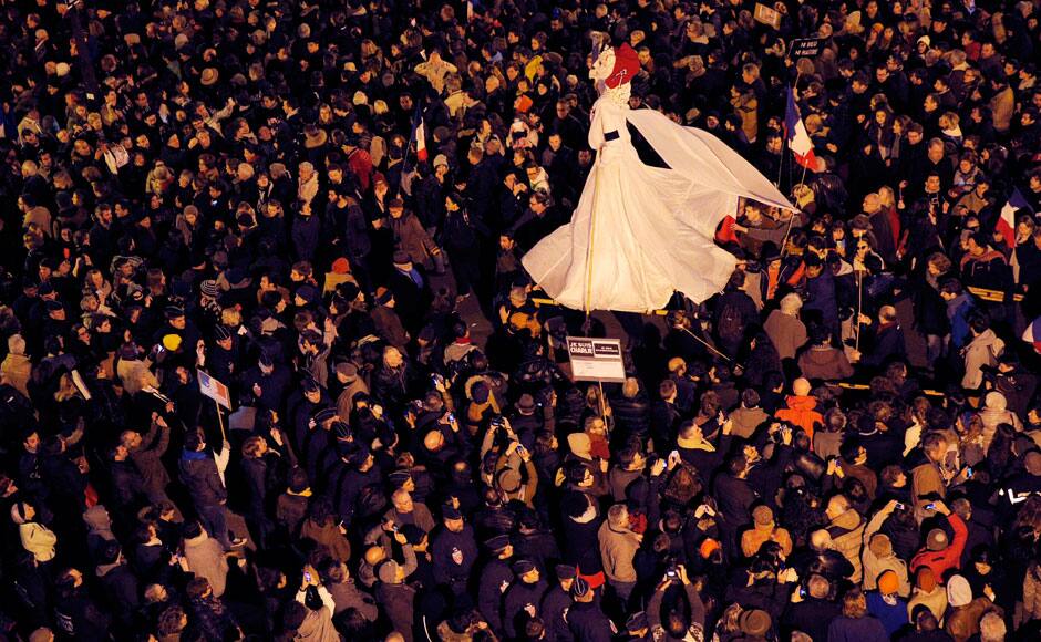 People attend a march , holding a large puppet depicting French symbol Marianne, in Paris, Sunday, Jan. 11, 2015. Hundreds of thousands gathered Sunday throughout Paris and cities around the world, to show unity and defiance in the face of terrorism that killed 17 people in France’s bleakest moment in half a century. AP