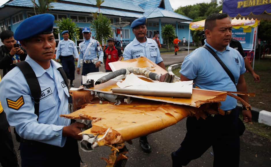 Indonesian Air Force personnel carry suspected debris after it was delivered by helicopter from a recovery mission for the missing AirAsia flight QZ850 at the airport in Pangkalan Bun, Central Kalimantan January 2, 2015. REUTERS