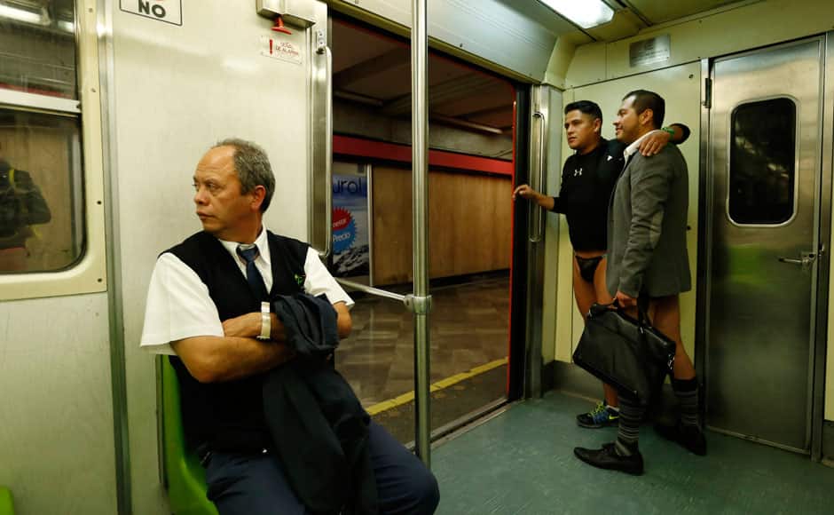 Men without pants ride a subway train during 
