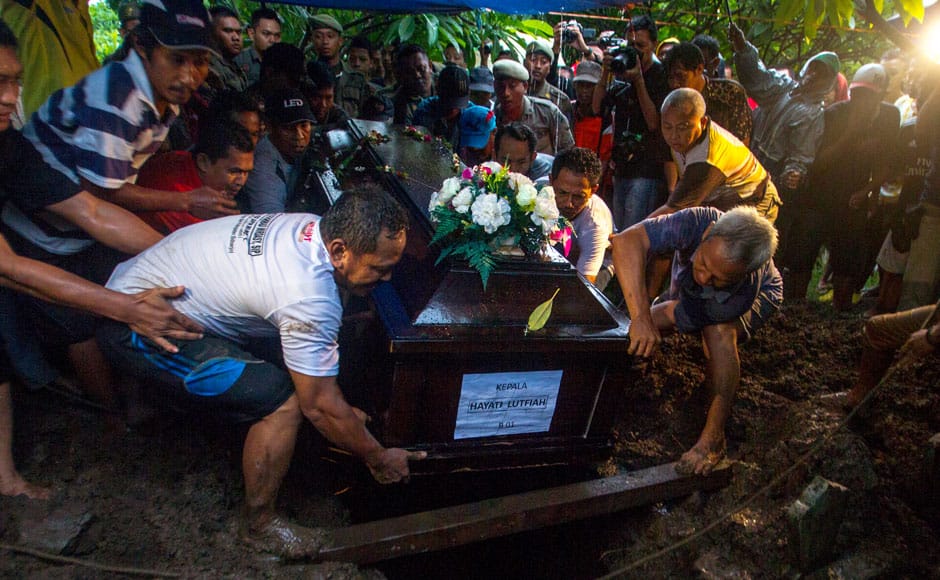 Relatives lower the coffin containing the body of Hayati Lutfiah, a passenger of AirAsia QZ8501, during her burial at a cemetery in Surabaya January 1, 2015. Heavy seas held back divers waiting to inspect the possible wreck of an AirAsia Indonesia jet off Borneo on Thursday and an aviation official said it could be a week before the black box flight recorders are found. REUTERS