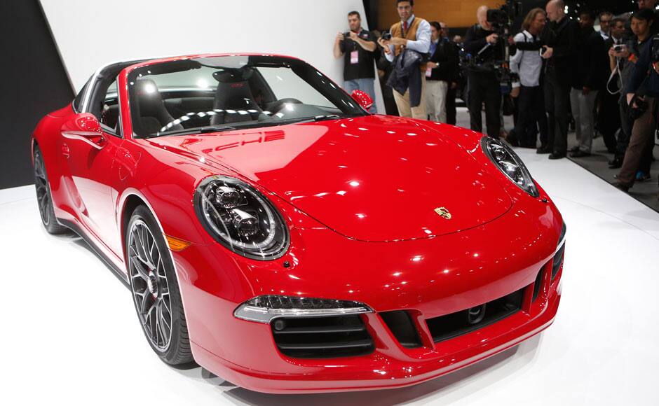 Members of the media take photographs of a Porsche 911 Targa GTS during its world premiere on the first press preview day of the North American International Auto Show in Detroit, Michigan January 12, 2015. REUTERS