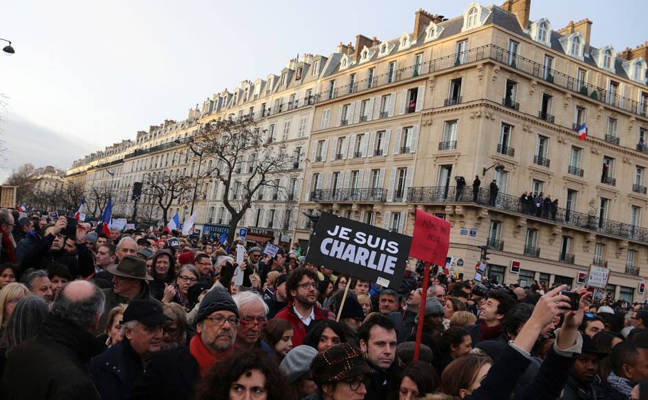 Thousand of people waves national flags and hold placards that read 