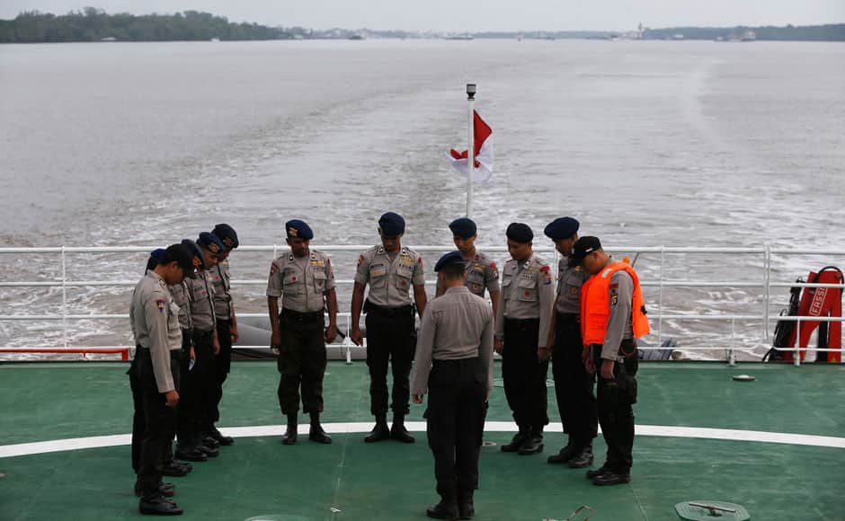 Indonesia policemen pray on deck of SAR ship KN Purworejo during a search operation for passengers onboard AirAsia flight QZ8501, in Java Sea, Indonesia January 3, 2015. Indonesia search and rescue teams hunting for the wreck of an AirAsia passenger jet have located four large objects in the Java Sea, agency chief Fransiskus Bambang Soelistyo told reporters on Saturday. The Indonesia AirAsia Airbus A320-200 plunged into the Java Sea on Sunday while en route from Indonesia's second-biggest city Surabaya to Singapore with 162 people on board. No survivors have been found. REUTERS