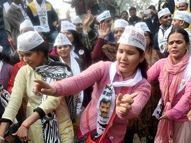 AAP supporters dance their way through a street during election campaigning. PTI 