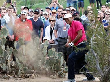 Tiger Woods hits out of the rough on the 11th hole. AP