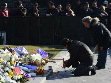 A couple burns incense at the site of a New Year’s Eve stampede at the Bund in Shanghai on January 2. AFP 
