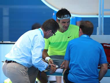 Roger Federer receives medical attention in his second round match against Simone Bolelli. Getty