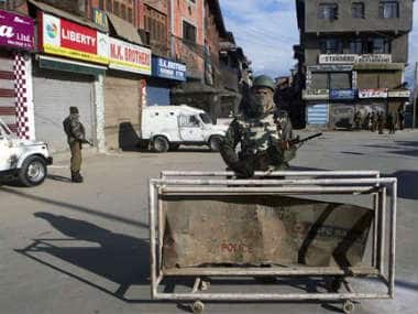An Indian soldier stands guard at a temporary checkpoint outside a closed market during a general strike in Srinagar, India. AP 