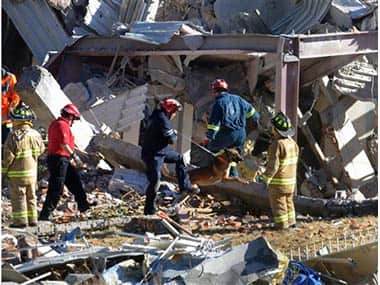 Rescue workers comb through the rubble of a children's hospital. AP