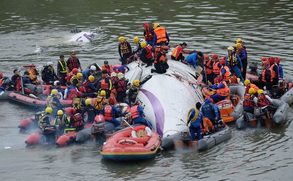 Rescue personnel work to free passengers from a TransAsia ATR 72-600 turboprop plane that crash-landed into a river outside Taiwan's capital Taipei in New Taipei City on February 4, 2015. The low-flying passenger plane, TransAsia Flight GE235 with 58 people on board, clipped a road bridge and plunged into the river outside Taiwan's capital with at least three feared dead and dozens trapped inside. AFP
