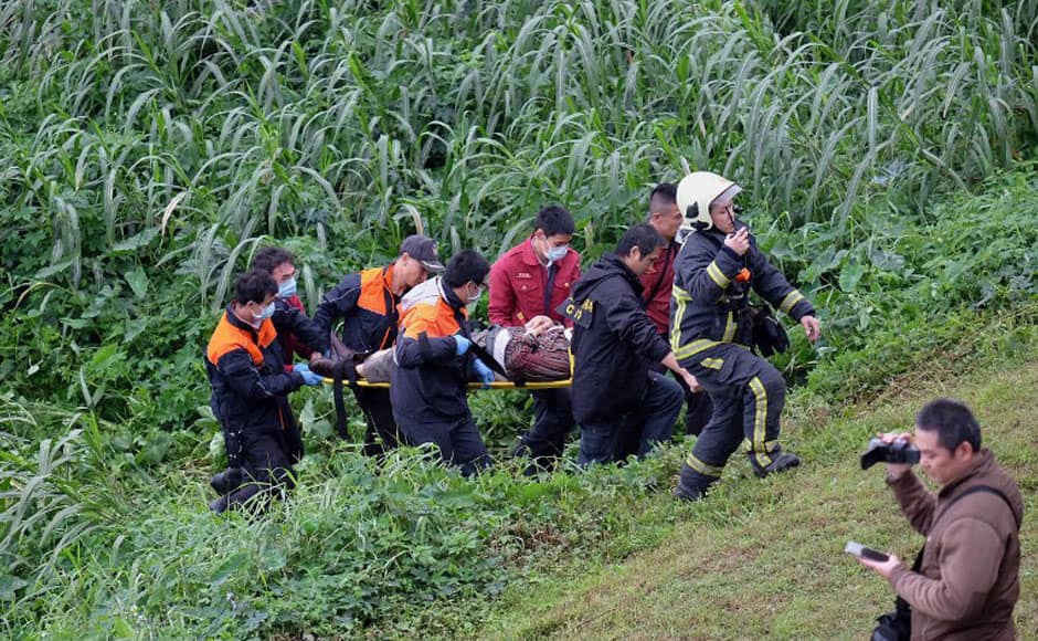 Rescue personnel carry a passenger from a TransAsia ATR 72-600 turboprop plane that crash-landed into a river outside Taiwan's capital Taipei on a stretcher in New Taipei City on February 4, 2015. The passenger plane with 58 people on board was on a domestic flight when it plunged into the river, with at least 10 people rescued and dozens trapped inside, according to television reports. AFP