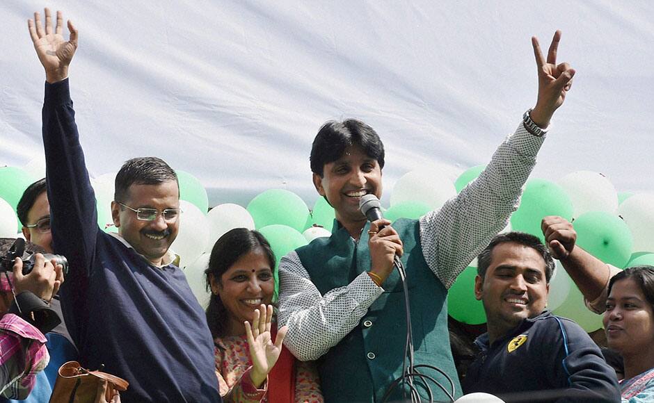 New Delhi: AAP convener Arvind Kejriwal with his wife and Kumar Vishwas waves at party volunteers as they celebrate the party’s victory in the Delhi Assembly polls, at Patel Nagar in New Delhi on Tuesday. PTI 