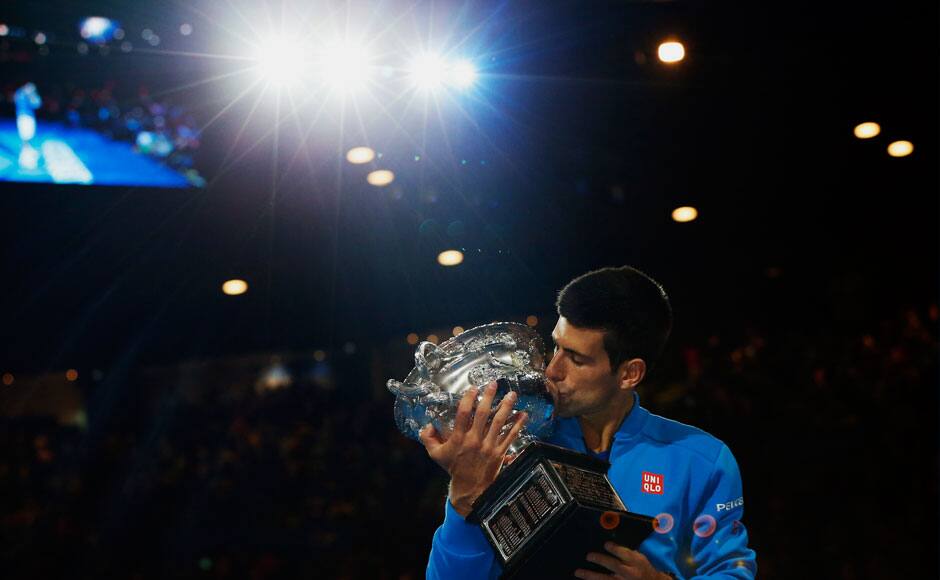 Novak Djokovic of Serbia kisses his trophy after defeating Andy Murray of Britain in their men's singles final match at the Australian Open 2015 tennis tournament in Melbourne February 1, 2015. REUTERS