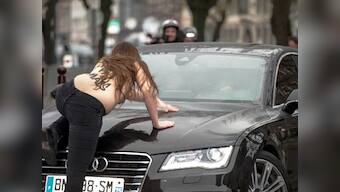 Topless Femen activists jump on Dominique Strauss-Kahn's car as he arrives for trial
