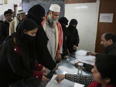 Indians stand in a queue to have their identities verified before proceeding to cast their votes at a polling station in New Delhi. AP 