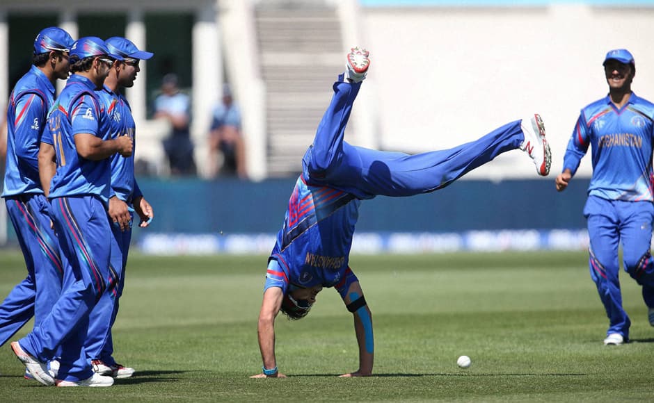 Afghanistan’s Hamid Hassan is watched by his teammates as he performs a hand-stand after taking a catch to dismiss Scotland's Josh Davey during their Cricket World Cup Pool A match in Dunedin, New Zealand - against Scotland. The Scots were limited to 210 all out. AFP