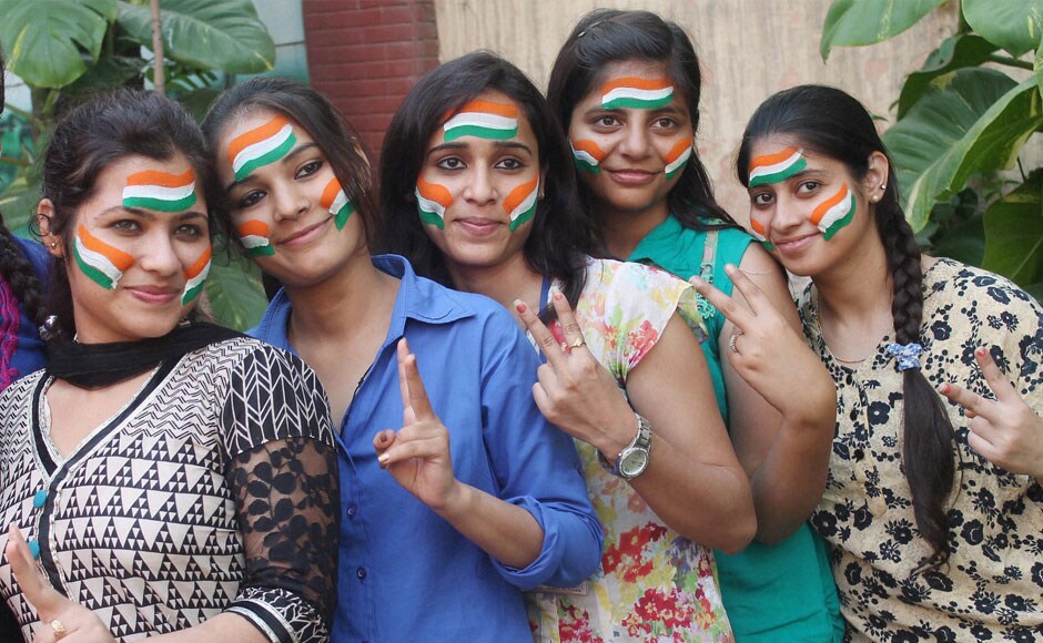 Cricket fans flash victory sign for the victory of Indian Cricket team against Australia in the semi final clash to be held in Sydney, in Faridabad on Wednesday. PTI