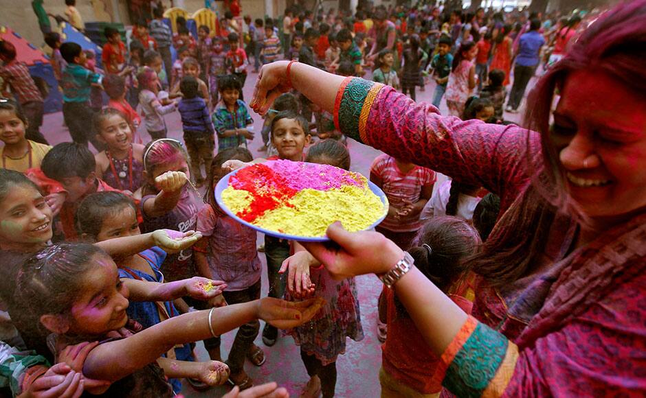 A teacher reacts as she distributes coloured powder among children as they celebrate Holi, also known as the Festival of Colours, at a school in the western Indian city of Ahmedabad March 5, 2015. The traditional event heralds the beginning of spring and will be celebrated all over India. REUTERS
