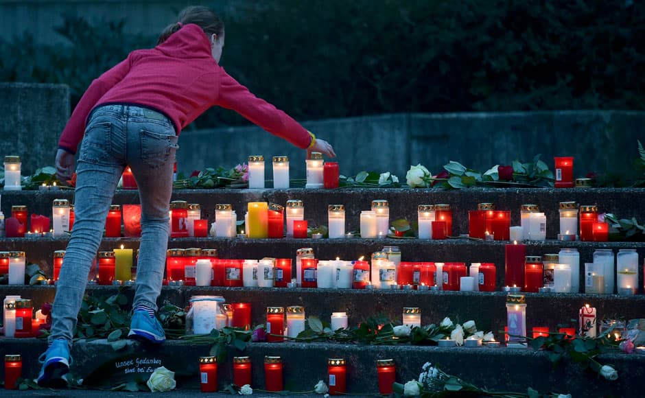 A student places a lit candle outside the Josef-Koenig-Gymnasium high school in Haltern am See, March, 24, 2015. Students and teachers at a small-town German high school broke out in ears when they realised that 16 classmates and two teachers were on board an ill-fated Germanwings airplane that crashed in France on Tuesday on a flight home to Duesseldorf. An Airbus operated by Lufthansa's Germanwings budget airline crashed in a remote snowy area of the French Alps on Tuesday, killing all 150 on board including 16 schoolchildren. REUTERS