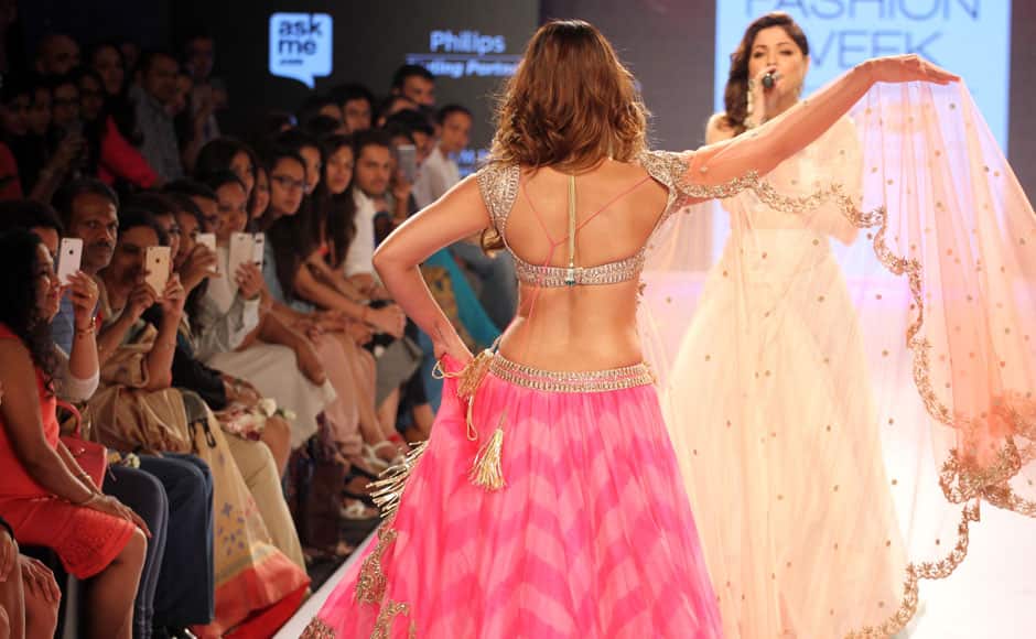 Bollywood singer Kanika Kapoor sings as Bollywood actress Ileana D'Cruz walks the runway displaying an outfit by designer Anushree Reddy, during the Lakme Fashion Week Summer/Resort 2015, in Mumbai, India on March 21, 2015. Solaris Images