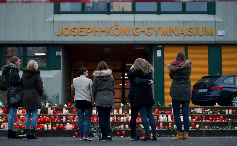 Students stand in front of lit candles outside the Josef-Koenig-Gymnasium high school in Haltern am See, March, 24, 2015. Students and teachers at a small-town German high school broke out in tears when they realised that 16 classmates and two teachers were on board an ill-fated Germanwings airplane that crashed in France on Tuesday on a flight home to Duesseldorf. An Airbus operated by Lufthansa's Germanwings budget airline crashed in a remote snowy area of the French Alps on Tuesday, killing all 150 on board including 16 schoolchildren. REUTERS