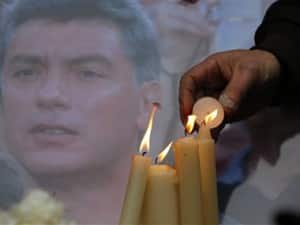 People light candles in memory of Boris Nemtsov, seen behind, at the monument of political prisoners ‘Solovetsky Stone’ in central St.Petersburg. AP
