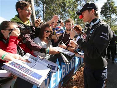 Mercedes driver Nico Rosberg of Germany wearing a funny red nose signs his autograph for a fan upon arrival at Albert Park for practice sessions for the Australian Formula One Grand Prix in Melbourne. AP