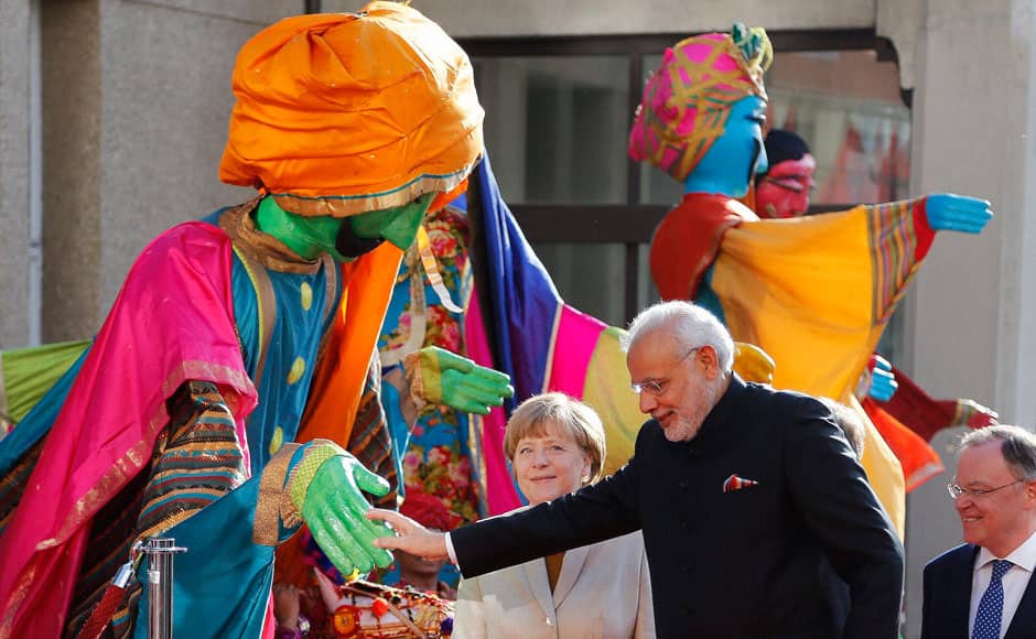 Hanover: German Chancellor Angela Merkel, welcomes India’s Prime Minister Narendra Modi, as a traditional Indian music group performs at the opening of the industrial fair in Hanover, Germany, Sunday.  PTI