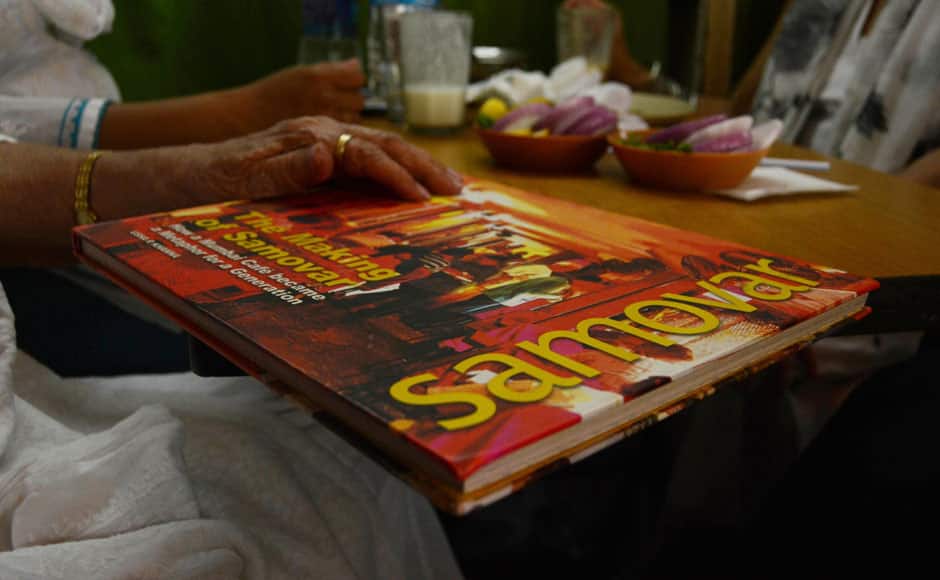 Cafe Samovar owner Usha Khanna displays her book on the last day of Cafe Samovar, in Mumbai, India on March 31, 2015. Cafe Samovar, the 50 year old eatery, a cultural and tourist destination synonymous with art, culture, literature, theatre and an integral part of being a Mumbaikar, lost out on its space in Jehangir Art Gallery after a court order. Solaris Images