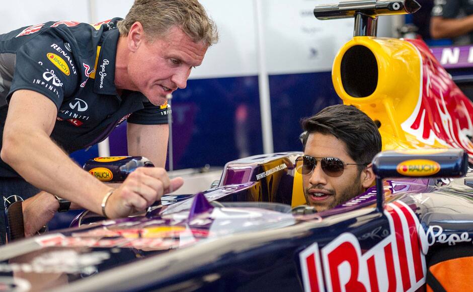 Former Formula One racing driver David Coulthard (L) of the Infiniti Red Bull Racing team, briefs Telugu actor Naga Chaitanya about the F1 car, moments before Coulthard drove twice around the Hussain Sagar lake in Hyderabad, India on April 5, 2015. Solaris Images