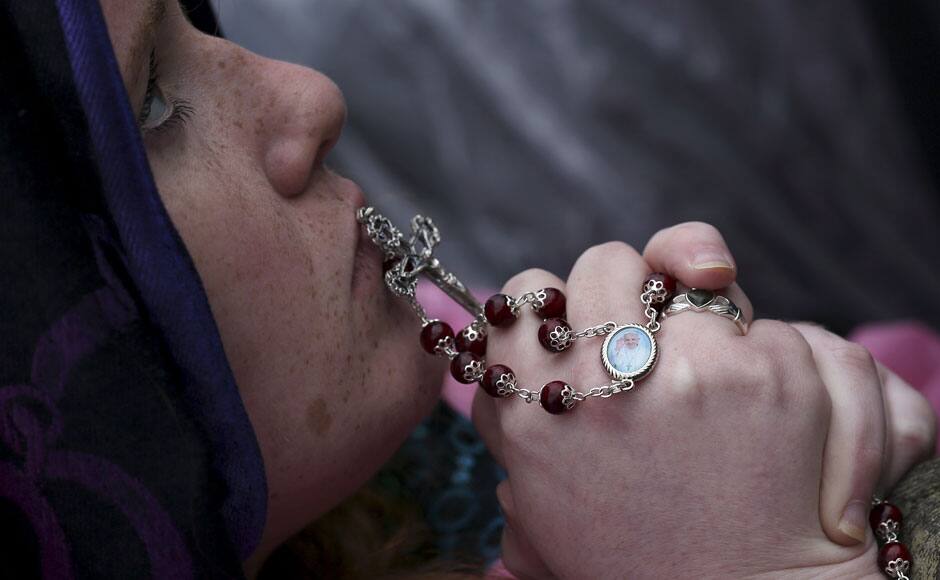 A faithful holds a rosary as Pope Francis leads the Easter Mass in St. Peter's square at the Vatican April 5, 2015. REUTERS