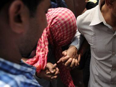 Policemen in plain clothes escort the juvenile accused (C) in the 2011 New Delhi gangrape case. AFP 