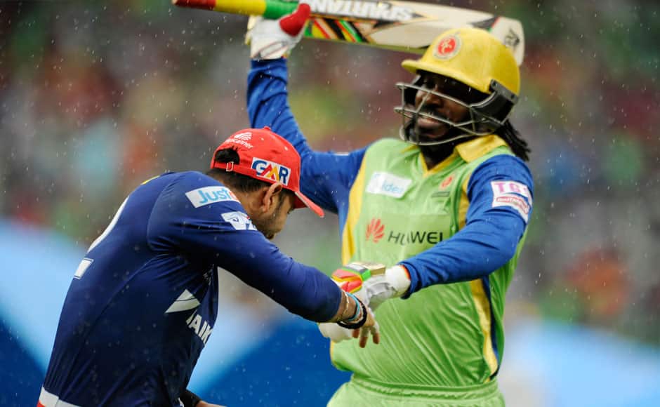 Chris Gayle of Royal Challengers Bangalore fakes to hit Yuvraj Singh of Delhi Daredevils with his bat while they run back to the pavilion as it starts to rain during match 55 of the Pepsi IPL 2015 (Indian Premier League) between The Royal Challengers Bangalore and The Delhi Daredevils held at the M. Chinnaswamy Stadium in Bengaluru, India on the 17th May 2015. sportzpics