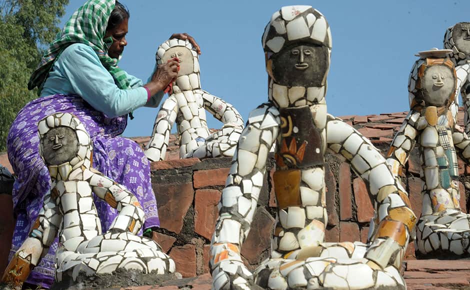 This photo taken on October 31, 2014 shows Indian visitors looking at sculptures at the Rock Garden, built by self-taught Indian artist Nek Chand Saini over the course of 18 years, in Chandigarh. Deep inside his massive garden of handmade waterfalls and sculptures, Nek Chand recalls toiling away secretly in the dead of night for a staggering 18 years to create his wonderland in north India. Riding his bicycle after dark to a state-owned forest, Chand spent night after night clearing patches of ground and transforming the landscape into a majestic garden that would eventually cover 20 acres (8 hectares). AFP 