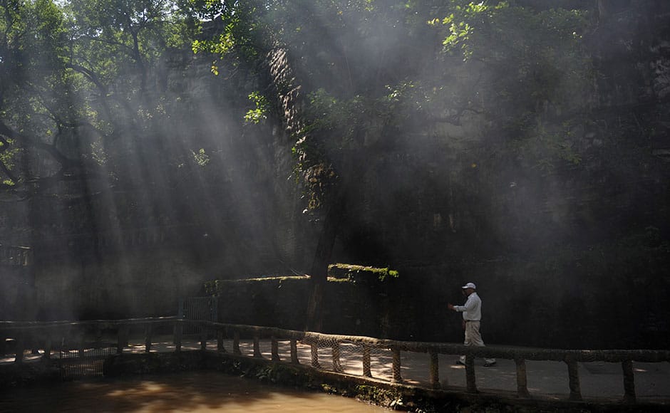 A tourist walks along a bridge in the Rock Garden in Chandigarh on September 28, 2010. Rock Garden of Chandigarh is a sculpture garden founded by Nek Chand where each of the featured artworks have been made using recycled industrial and urban waste. AFP